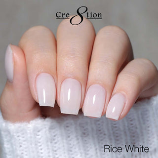 Nails with a light pink manicure on a neutral background, featuring the brand 'Cre8tion'.
