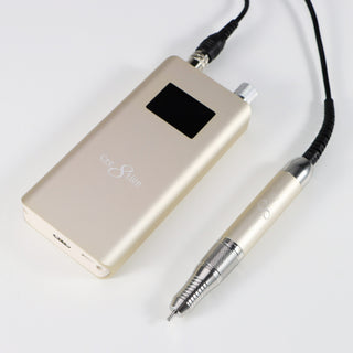 Cream beige Cre8tion cordless e-file handpiece and control unit on a pale gray surface