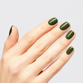 Open hand with almond nails in a deep olive green gel, light gray studio background
