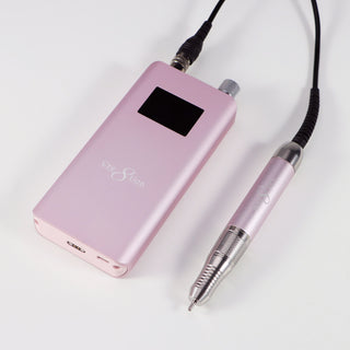 Pink blossom Cre8tion cordless e-file handpiece and control unit on a pale gray surface