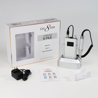 Silver Cre8tion cordless e-file in its window box with charger, bits and a white cradle