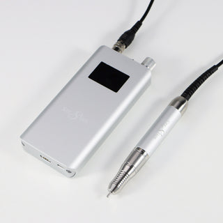 Silver Cre8tion cordless e-file handpiece and control unit on a pale gray surface