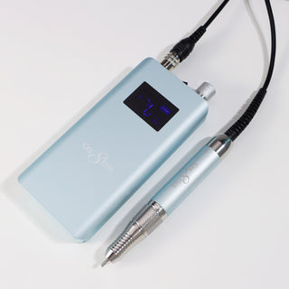 Sky blue Cre8tion cordless e-file handpiece and control unit on a pale gray surface